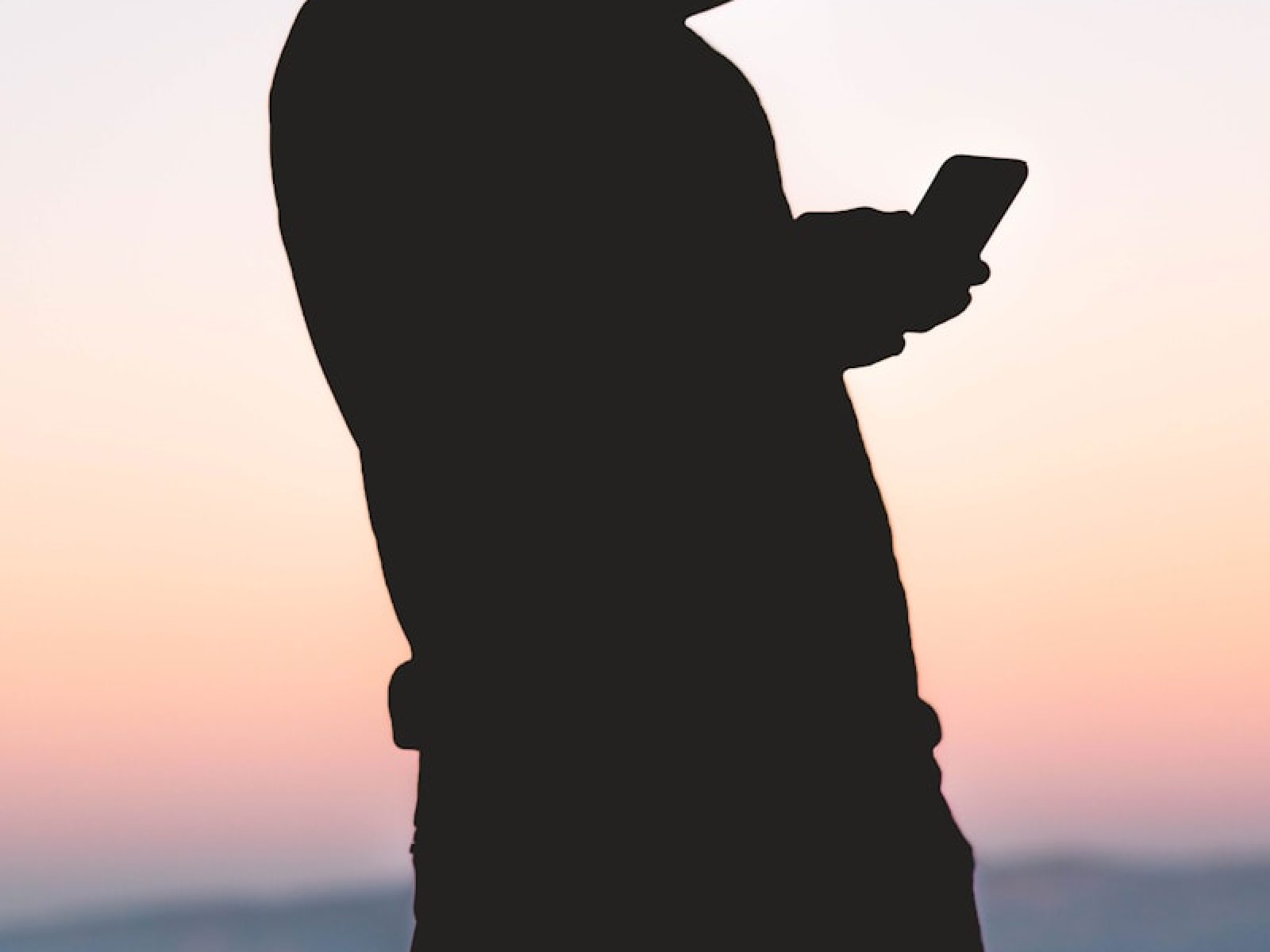 silhoutte of person using smartphone